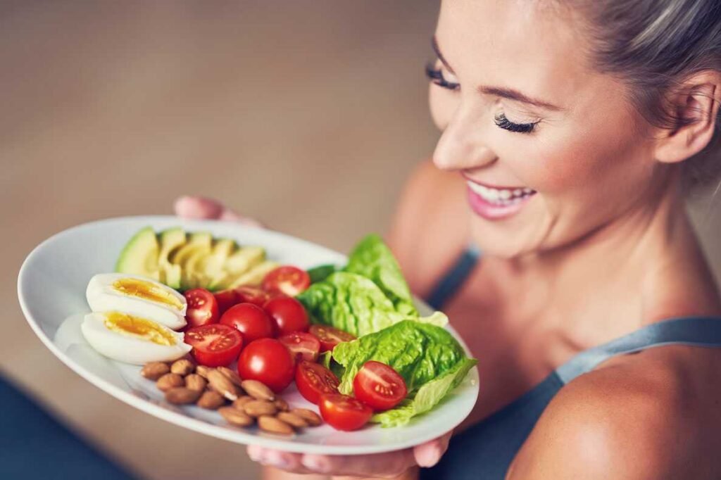 Mulher adulta comendo almoço saudável e sentada no tapete de ioga