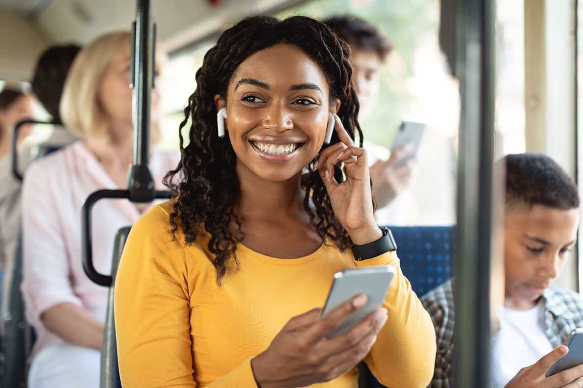 Mulher feliz num autocarro a ouvir música nos fones