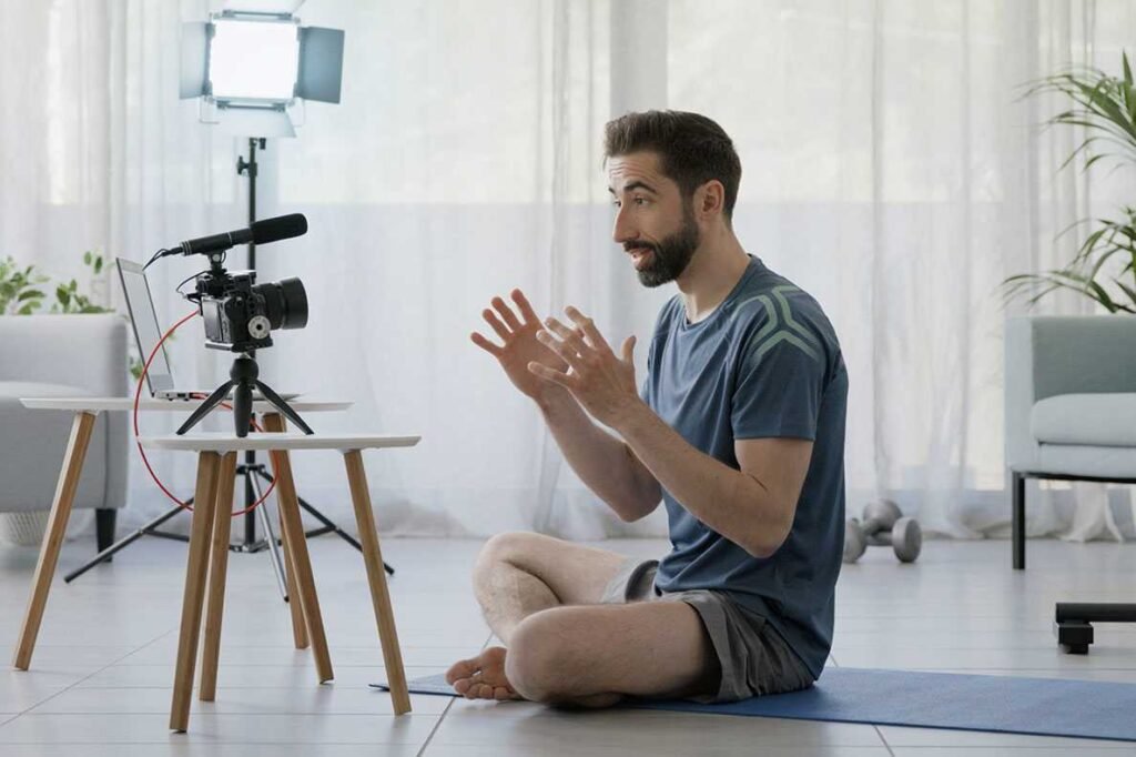Um sentado num tapete de yoga em casa em frente de uma camara