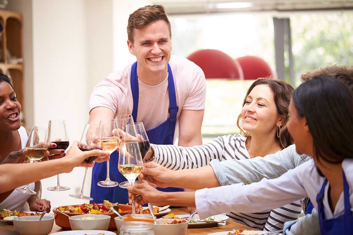 Amigos a brindar á volda de uma mesa durante o almoço