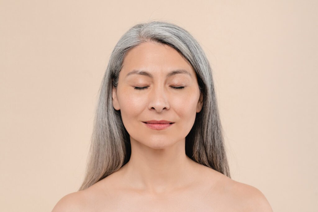 Mulher com idade e cabelo branco bemconservada com a pele jovem