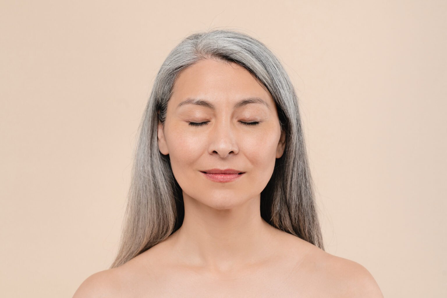 Mulher com idade e cabelo branco bemconservada com a pele jovem