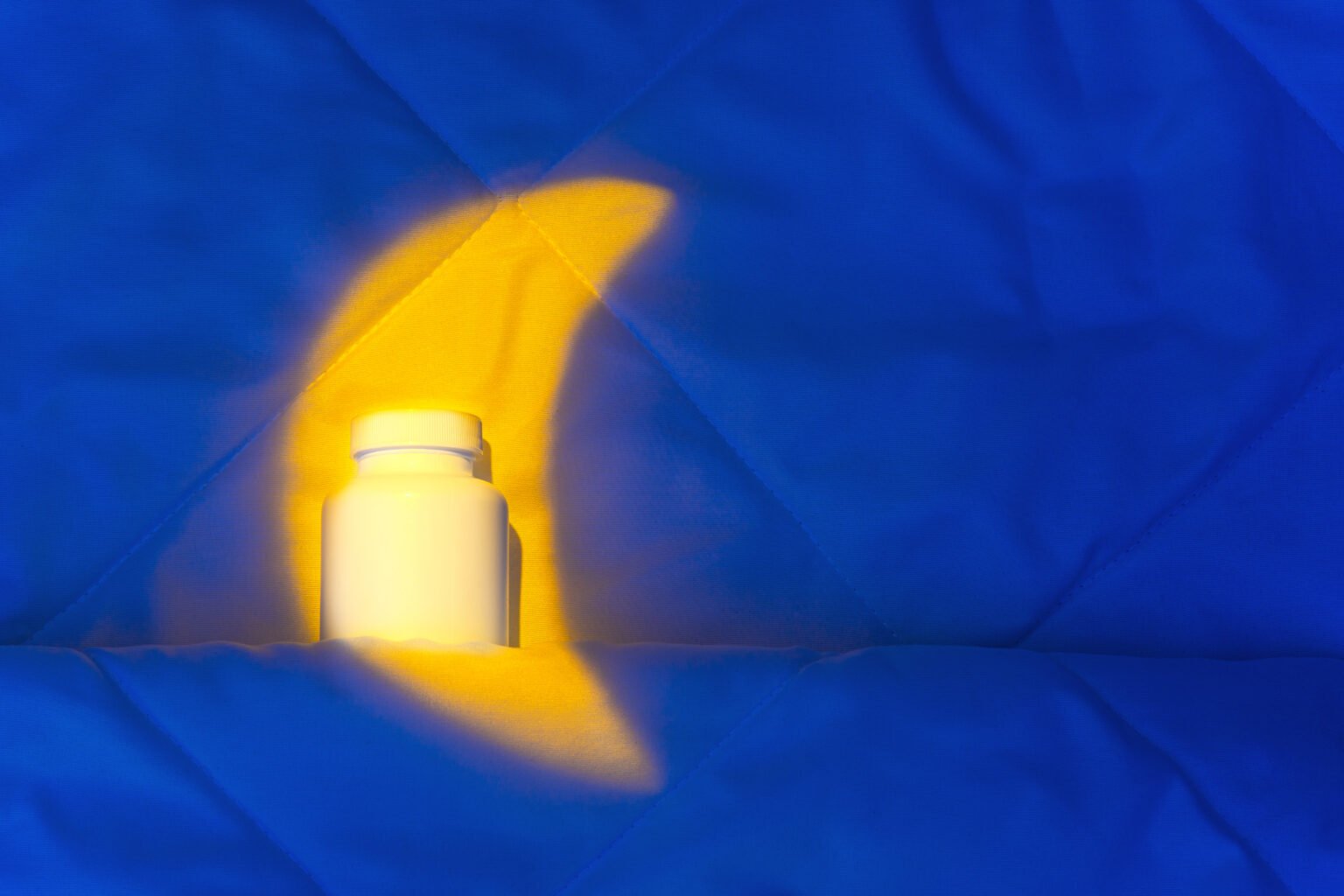 jarro de vitaminas em cima de um cobertor iluminado por uma lampada em formato de lua