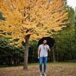 homem com um guarda chuva num parque