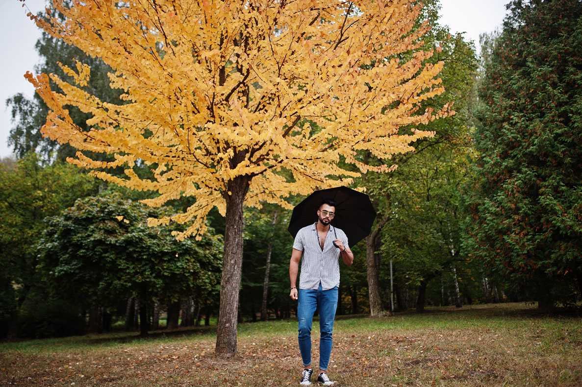 homem com um guarda chuva num parque