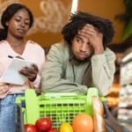 casal afrodescendente a fazer compras com um ar preocupado