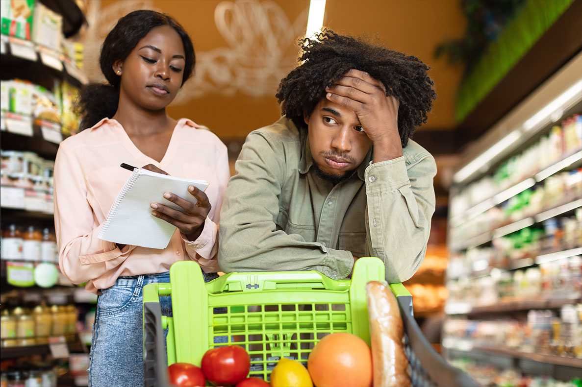 casal afrodescendente a fazer compras com um ar preocupado